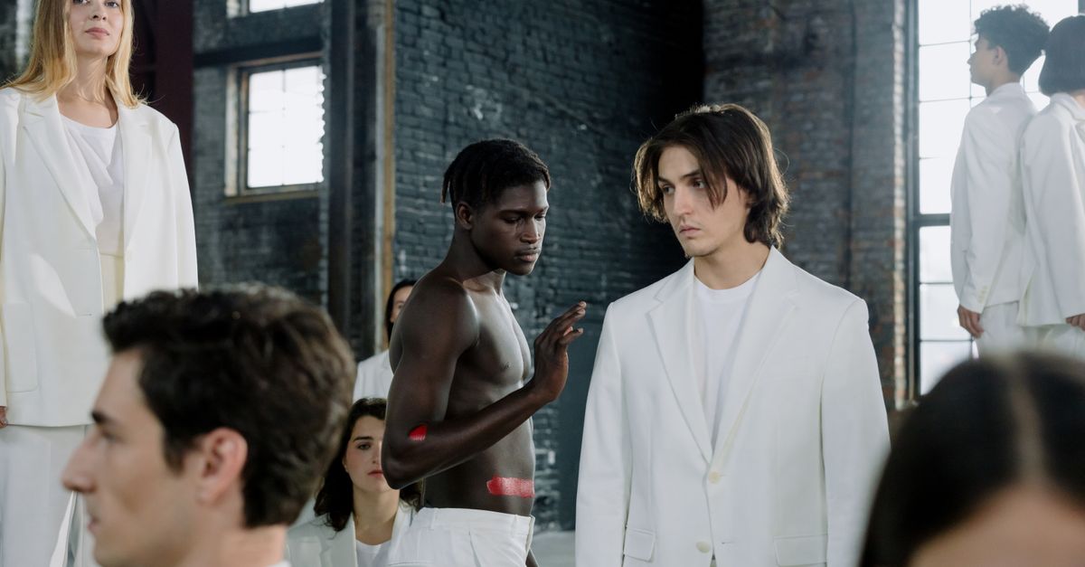 Models in a fashion shoot wearing white outfits in an industrial space.